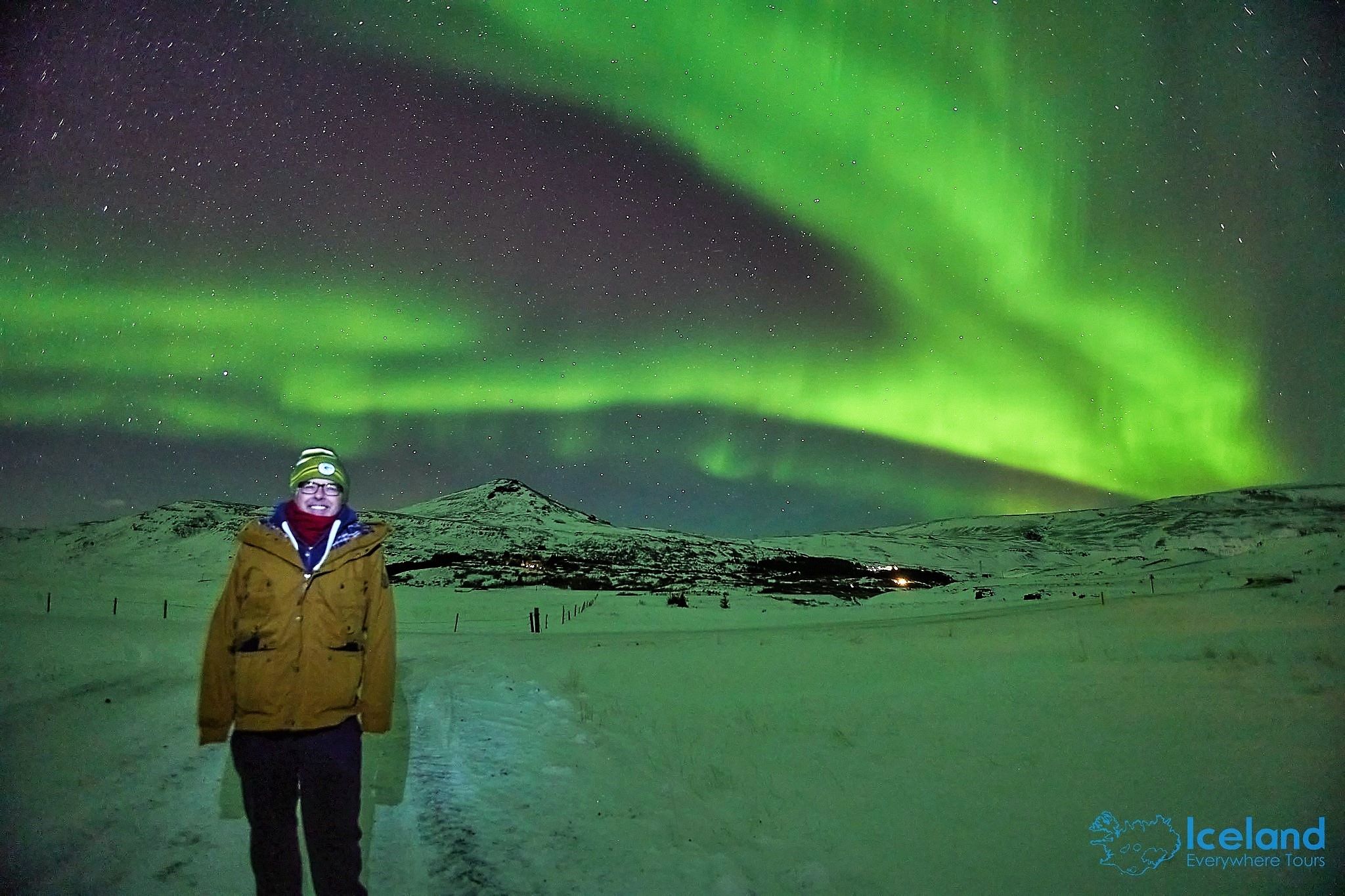 Andy smiling while embracing the sight of aurora borealis on the sky at night