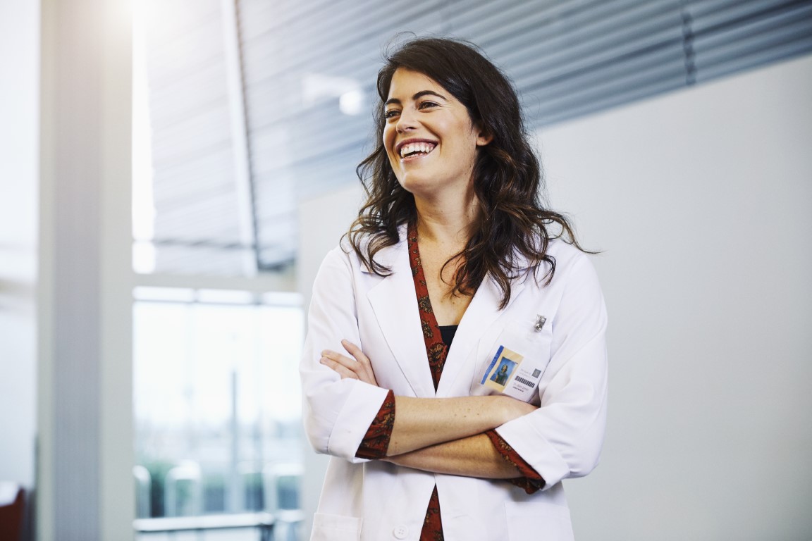 Clinician with her arms crossed laughing at something
